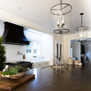 Photo of a large transitional single-wall kitchen pantry in San Diego with an undermount sink, recessed-panel cabinets, white cabinets, marble benchtops, white splashback, terra-cotta splashback, stainless steel appliances, medium hardwood floors and with island.