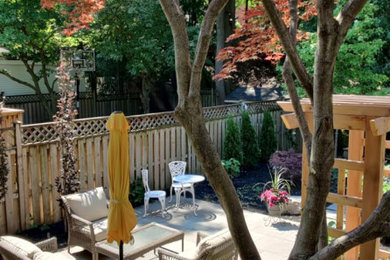Diseño de patio clásico renovado de tamaño medio sin cubierta en patio trasero con adoquines de piedra natural