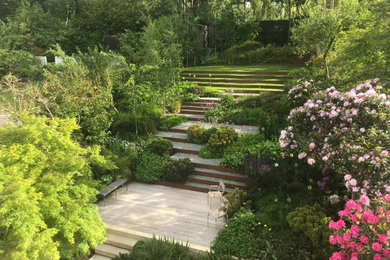 Photo of a large contemporary backyard formal garden in London with a garden path.