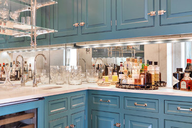 Example of a dark wood floor wet bar design in New York with an undermount sink, raised-panel cabinets, mirror backsplash and white countertops