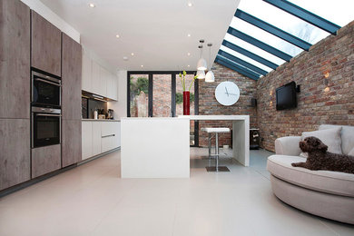 Large contemporary open plan kitchen in London with flat-panel cabinets and with island.