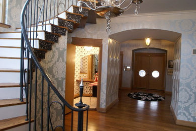 Idée de décoration pour une très grande entrée bohème avec un couloir, un mur bleu, un sol en bois brun, une porte simple et une porte en bois clair.