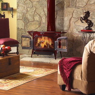 Mittelgroßes, Abgetrenntes, Fernseherloses, Repräsentatives Mediterranes Wohnzimmer mit gelber Wandfarbe, Kaminofen, Kaminsims aus Metall, braunem Boden und braunem Holzboden in Philadelphia