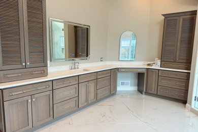Design ideas for a large classic ensuite bathroom in Philadelphia with louvered cabinets, brown cabinets, a freestanding bath, a corner shower, a one-piece toilet, white tiles, stone tiles, grey walls, marble flooring, a submerged sink, quartz worktops, white floors, a hinged door, white worktops, an enclosed toilet, double sinks, a built in vanity unit, exposed beams and tongue and groove walls.