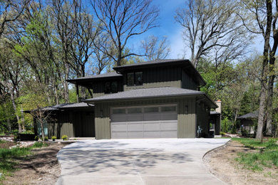 Example of a 1950s brown two-story wood and board and batten house exterior design in Chicago with a hip roof and a shingle roof