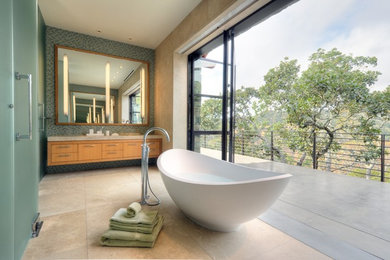 Example of a trendy blue tile and mosaic tile travertine floor freestanding bathtub design in San Francisco with flat-panel cabinets and medium tone wood cabinets