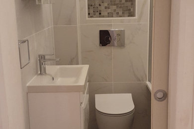 Photo of a modern shower room bathroom with glass-front cabinets and white cabinets.