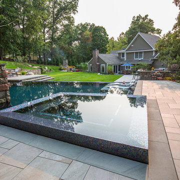 Clean line infinity edge with peremiter overflow spa and detailed stonework
