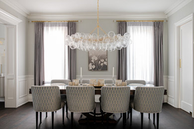 Inspiration for a mid-sized transitional dark wood floor, brown floor and wainscoting enclosed dining room remodel in Toronto with gray walls