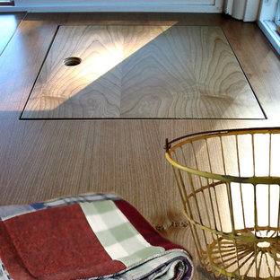 Immagine di un piccolo soggiorno american style aperto con libreria, pareti beige, parete attrezzata, pavimento in legno massello medio, camino classico e cornice del camino in mattoni