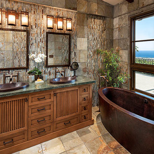 Ispirazione per una stanza da bagno padronale tropicale di medie dimensioni con ante con riquadro incassato, ante in legno scuro, vasca freestanding, lavabo da incasso, top in granito, pavimento marrone e top verde