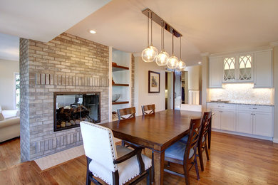 Design ideas for a large transitional kitchen/dining combo in Denver with white walls, medium hardwood floors, a two-sided fireplace, a brick fireplace surround and brown floor.