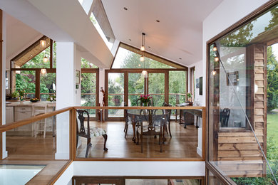 Inspiration for a medium sized country l-shaped kitchen/diner in Wiltshire with a belfast sink, recessed-panel cabinets, grey cabinets, tile countertops, brown splashback, terracotta splashback, stainless steel appliances, light hardwood flooring, an island and brown floors.