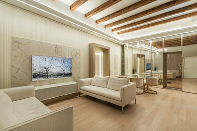 Foto de salón abierto de tamaño medio con paredes blancas, suelo de madera clara, televisor colgado en la pared, vigas vistas y boiserie