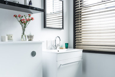 Photo of a small contemporary shower room bathroom in London with a wall-mounted sink, a corner shower, a one-piece toilet, white tiles, ceramic tiles, white walls and vinyl flooring.