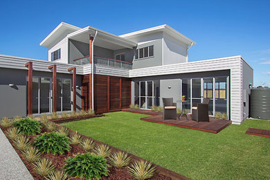 Mid-sized contemporary two-storey grey exterior in Gold Coast - Tweed with mixed siding and a flat roof.
