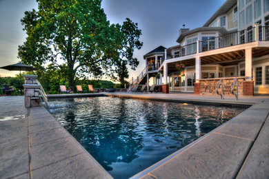 Inspiration for a large contemporary backyard stamped concrete and rectangular natural pool fountain remodel in Cedar Rapids