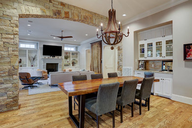 Example of a mid-sized transitional medium tone wood floor and beige floor dining room design in Houston with beige walls and a standard fireplace