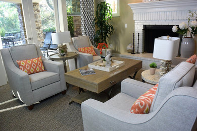 Photo of a large beach style open concept living room in Orange County with grey walls, carpet, a standard fireplace, a brick fireplace surround and no tv.