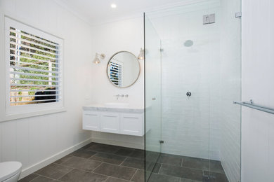 Large country bathroom in Other with white cabinets, a corner shower, a one-piece toilet, white tile, ceramic tile, white walls, ceramic floors, an integrated sink, marble benchtops, grey floor, a hinged shower door and grey benchtops.