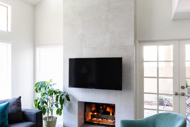 Inspiration for a large modern open concept laminate floor and gray floor family room remodel in San Diego with white walls, a standard fireplace, a tile fireplace and a wall-mounted tv