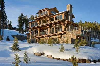 Huge modern multicolored three-story stone exterior home idea in Other with a clipped gable roof
