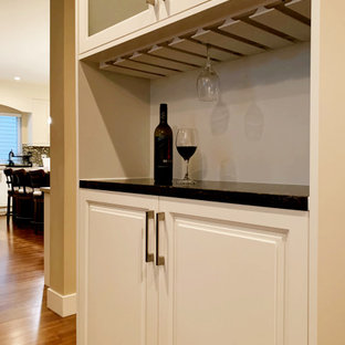 バンクーバーの中サイズのおしゃれなバーカート (ドロップインシンク、白いキャビネット、木材カウンター、白いキッチンパネル、木材のキッチンパネル、合板フローリング、白い床、白いキッチンカウンター) の写真