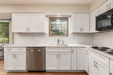 Inspiration for a mid-sized transitional l-shaped eat-in kitchen remodel in Columbus with shaker cabinets, white cabinets, quartz countertops, white backsplash, ceramic backsplash and white countertops