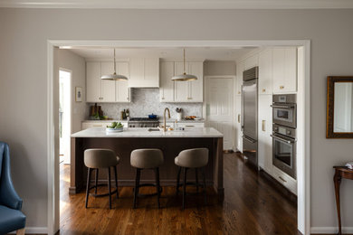 Large transitional l-shaped medium tone wood floor and brown floor kitchen photo in DC Metro with an undermount sink, shaker cabinets, white cabinets, quartzite countertops, white backsplash, marble backsplash, stainless steel appliances, an island and gray countertops
