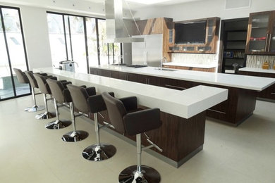 Design ideas for a large galley eat-in kitchen in Los Angeles with a double-bowl sink, glass-front cabinets, dark wood cabinets, quartz benchtops, beige splashback, glass tile splashback, stainless steel appliances, ceramic floors, multiple islands, beige floor, white benchtop and vaulted.