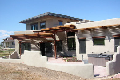 Example of a mid-sized trendy beige two-story stucco exterior home design in Denver