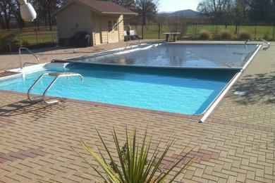 Backyard brick and rectangular lap pool photo in Other