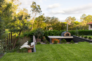 Inspiration for a modern garden in Brisbane with with fireplace.