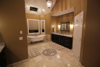 Design ideas for a large traditional master bathroom in New York with recessed-panel cabinets, dark wood cabinets, a claw-foot tub, an alcove shower, a one-piece toilet, beige tile, marble, black walls, marble floors, an undermount sink, marble benchtops, beige floor and a hinged shower door.
