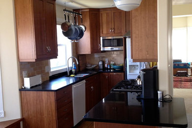 Inspiration for a small timeless u-shaped light wood floor enclosed kitchen remodel in Denver with granite countertops, stainless steel appliances, a drop-in sink, shaker cabinets, medium tone wood cabinets, beige backsplash, subway tile backsplash and no island