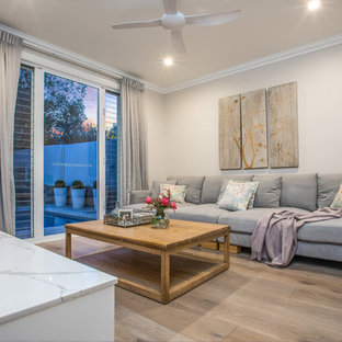 Small traditional enclosed home cinema in Brisbane with beige walls, painted wood flooring, a wall mounted tv and beige floors.