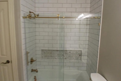 Inspiration for a mid-sized transitional master white tile and subway tile porcelain tile and white floor bathroom remodel in Other with shaker cabinets, medium tone wood cabinets, a two-piece toilet, white walls, an undermount sink, granite countertops, white countertops, a niche and a built-in vanity