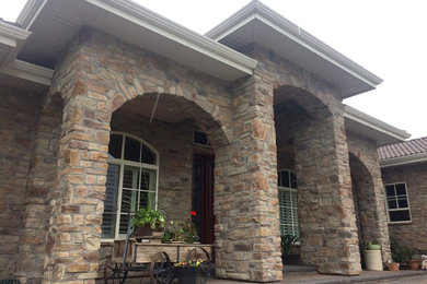 Large tuscan two-story stone house exterior photo in Vancouver