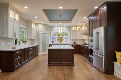 Large trendy u-shaped medium tone wood floor, brown floor and tray ceiling open concept kitchen photo in San Francisco with an undermount sink, recessed-panel cabinets, dark wood cabinets, quartz countertops, white backsplash, glass tile backsplash, stainless steel appliances, an island and white countertops