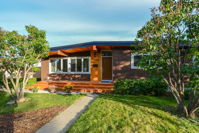 Example of a mid-sized transitional brown one-story mixed siding exterior home design in Calgary with a hip roof