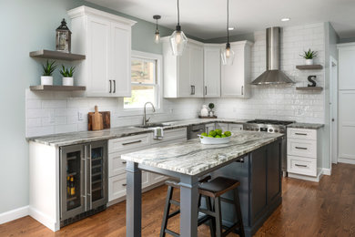 Eat-in kitchen - mid-sized transitional l-shaped medium tone wood floor and brown floor eat-in kitchen idea in St Louis with an undermount sink, flat-panel cabinets, white cabinets, granite countertops, white backsplash, ceramic backsplash, stainless steel appliances, an island and multicolored countertops