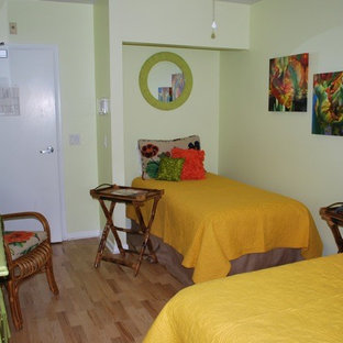 Ispirazione per una piccola camera degli ospiti etnica con pareti verdi, pavimento in bambù e nessun camino