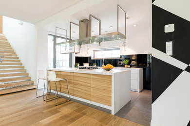 Kitchen - large modern ceramic tile and gray floor kitchen idea in Los Angeles with an undermount sink, white cabinets, black backsplash, an island and white countertops