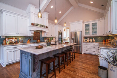 Large elegant u-shaped medium tone wood floor and brown floor eat-in kitchen photo in Little Rock with a farmhouse sink, raised-panel cabinets, white cabinets, granite countertops, blue backsplash, porcelain backsplash, stainless steel appliances and an island