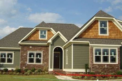 Example of a large arts and crafts green two-story vinyl house exterior design in Other with a gambrel roof and a shingle roof