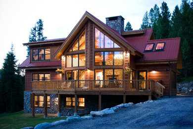 Example of a large mountain style three-story wood exterior home design in Other