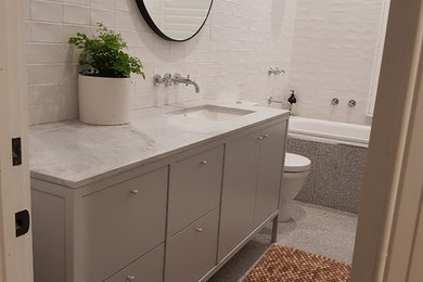 Design ideas for a mid-sized traditional master bathroom in Melbourne with shaker cabinets, white tile, ceramic tile, an undermount sink and marble benchtops.