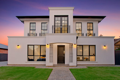 Photo of a large traditional two-storey brick white house exterior in Adelaide with a hip roof and a tile roof.