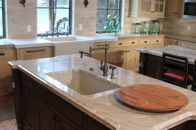 Eat-in kitchen - large contemporary u-shaped medium tone wood floor and brown floor eat-in kitchen idea in Other with an integrated sink, recessed-panel cabinets, light wood cabinets, quartzite countertops, paneled appliances, beige backsplash, stone slab backsplash and two islands