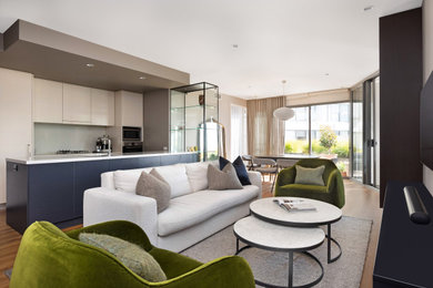 Photo of a mid-sized eclectic formal enclosed living room in Canberra - Queanbeyan with beige walls, light hardwood floors and a built-in media wall.